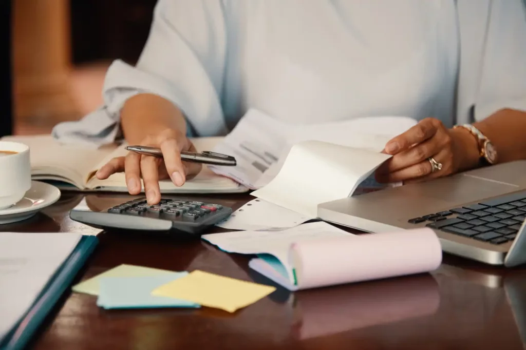 Pessoa negativa com financiamento analisando documentos e contas, representando dificuldades financeiras e opções de renegociação de dívida.